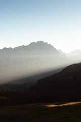 First ray of light over a misty morning in the Dolomites Italy