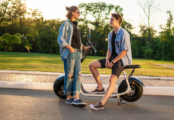 Lovely young couple with electric bike. Modern city transportation