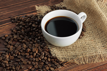 Coffee cup and coffee beans on wooden background