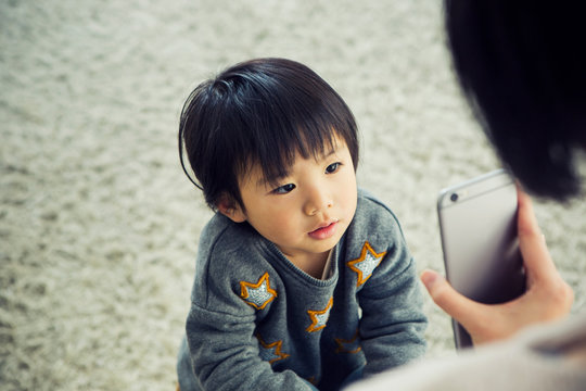 スマホを見せらせる男の子