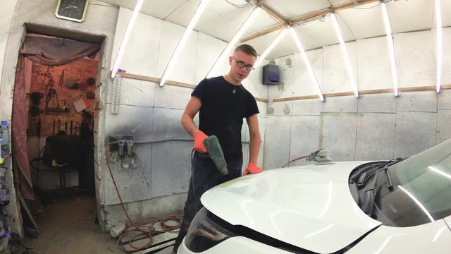 young man repairs cars in the garage.
