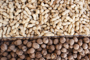 The counter peeled peanuts and walnuts are separated by a glass partition in a nut shop. Background. View from above