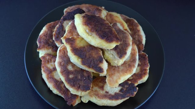 Potato cakes, ukrainian name potato zrazy, stuffed mushrooms or meat or cheese with herbs cream are fried in vegetable oil on black background, close up, rotates. Traditional Ukrainian cuisine