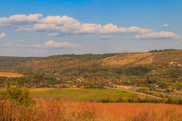 Picturesque autumn scenery with blue sky and colorful autumn trees on mountain hills