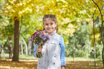 Beautiful happy girl in autumn park.