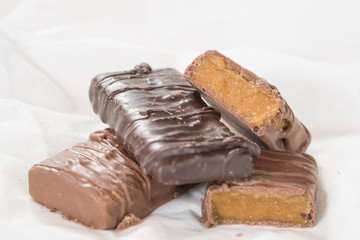 CHOCOLATE BARS WITH TOFFEE CARAMEL ON WHITE NAPKIN (COPY SPACE)