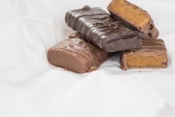 CHOCOLATE BARS WITH TOFFEE CARAMEL ON WHITE NAPKIN (COPY SPACE)