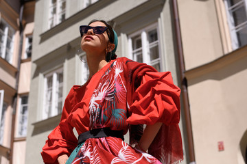 Young spanish woman in a red blouse and green pants. Fashion latin look. Woman walking in old town...