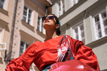 Fototapeta premium Fashion portrait of young spanish woman in sunglasses. Fashion latin look. Woman walking in old town