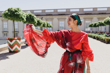 Young spanish woman in a red blouse and green pants. Fashion latin look. Flamenco woman smiling
