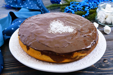 A big festive chocolate cake, a heart of coconut in the middle.