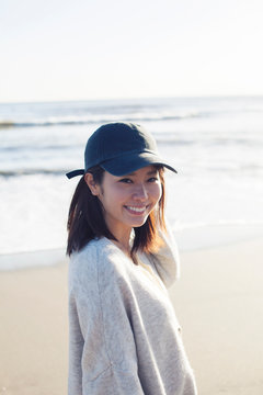 波打ち際で笑顔の20代女性