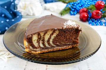 A piece of delicious two-color cake with chocolate and coconut chips. Festive cake.