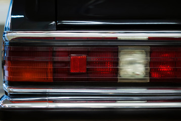 Obraz premium fragment of the backlight of a black vintage luxury car