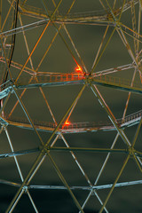 night industrial background - fragment of a lattice tower with luminous aircraft warning lights