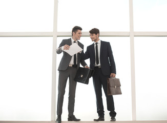 business people with leather briefcases standing near the office