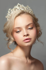 Beautiful blond girl in the image of a bride with a tiara in her hair. Picture taken in the studio...