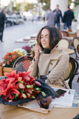 Young beautiful woman drinking coffee in a street cafe