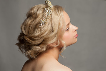 Beautiful blond girl in the image of a bride with a tiara in her hair. Picture taken in the studio...