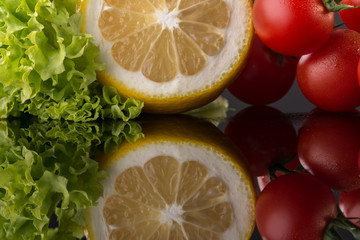 Salad vegetables with reflection at black background.Close up shoot