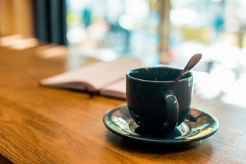 cup of coffee with spoon on wooden tabletop in cafe