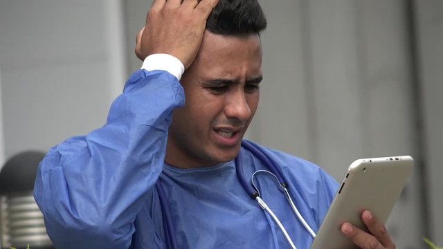 Stressed Hispanic Male Surgeon With Tablet