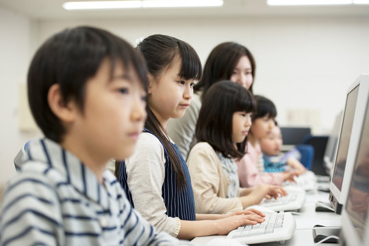 Students studying on desktop computers in classroom