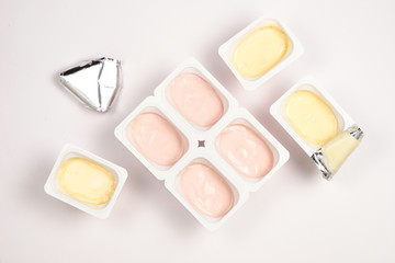 Plastic cup with tasty yogurt isolated on white. Top view. Space for text or design.