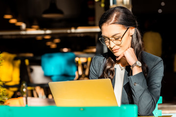 beautiful freelancer working with laptop on restaurant terrace