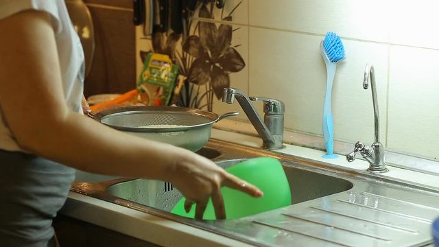 housewife washes rice in the kitchen for cooking pilaf at home