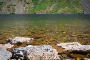 Fototapeta na wymiar Rocks in crystal clear water of Wast Water lake in the Lake District National Park, the UK