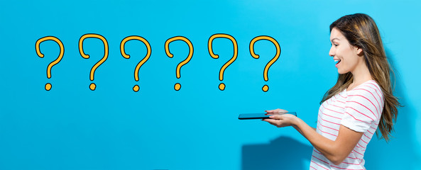 Question marks with young woman using her tablet