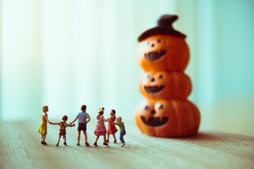 Miniature children looking at ghost pumpkin using as family and halloween concept
