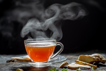 Hot Ginger tea in a glass on wood background.Hot drink . Copy space.