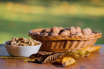 walnuts and leaves from a tree on a wooden table, autumn concept