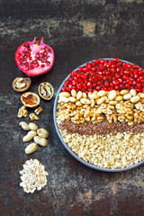 Vegan bowl of oatmeal, nuts, flax seeds and pomegranate. Healthy breakfast or snack. Keto breakfast idea. The concept of a healthy and beautiful meal.