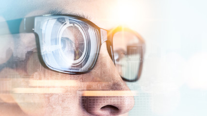 The abstract image of the businessman wear a smart glasses overlay with futuristic hologram. The concept of modern life, technology, iris scanner and internet of things