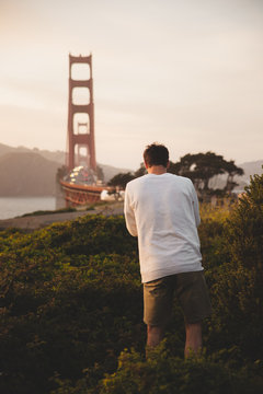 Anonymous man taking picture of bridge