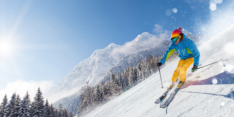 Skiër skiën bergafwaarts in hoge bergen