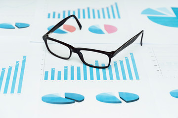 Brille auf einem Schreibtisch mit Finanz Unterlagen