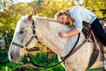 A Beautiful teen girl on the farm with her horse.