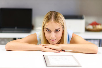 Obraz premium Studio photo of a beautiful blonde girl is talking in an office sitting at a table.