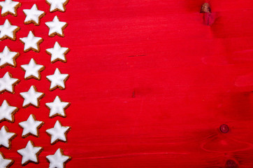 star shaped christmas cookies on a red wooden background
