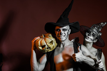 Halloween couple with makeup on brown background. © Volodymyr