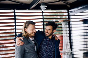 Two hugged male colleagues