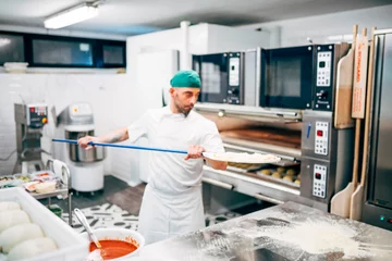 Foto auf Acrylglas Der Mann arbeitet im Restaurant und macht Pizza in der Pizzeria. © OscarStock