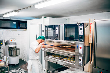 Man works in the restaurant making pizza at the pizzeria.