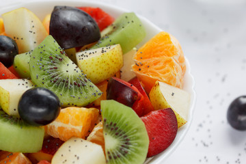 Fresh salad from kiwi, oranges, plums and other fruits close up. Healthy lifestyle.