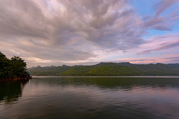 Landscape of the mountain and The ship is on the river with blue sky in the morning. View of the mountain with blue sky at Srinakarin Dam , Kanchanaburi province , Thailand.