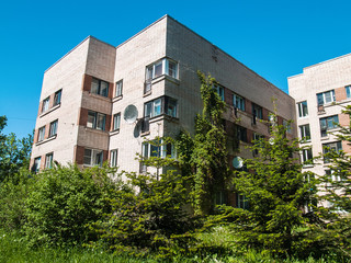Residential five-story building of light brick in St. Petersburg in the summer against the blue sky